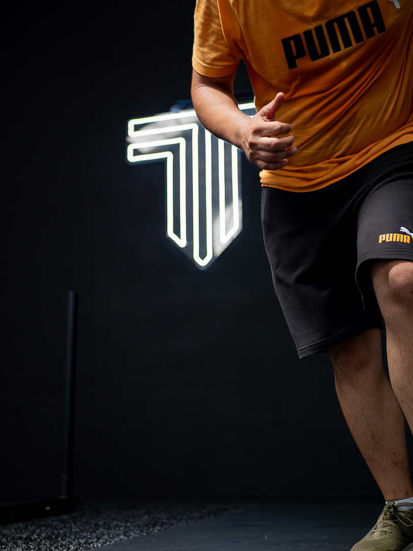 Athlete training under branded gym lighting