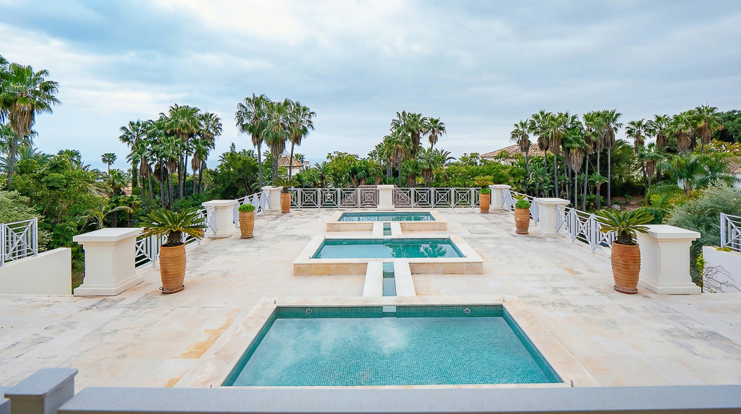 Luxury estate terrace with layered pools and palms