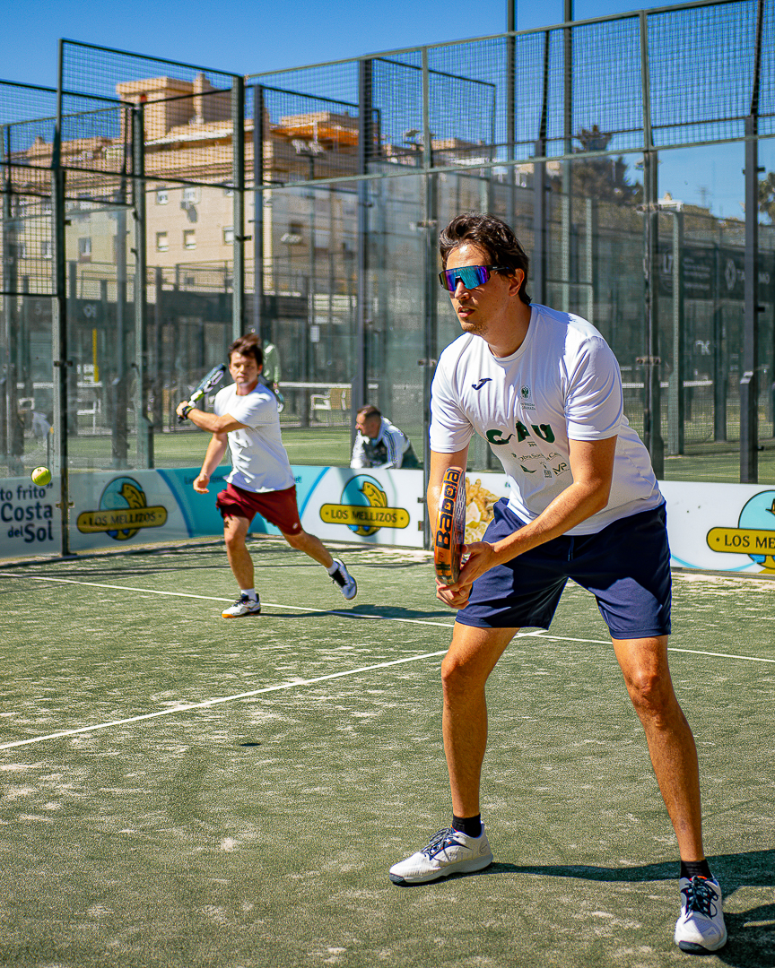 Competitive padel doubles action under strong sun