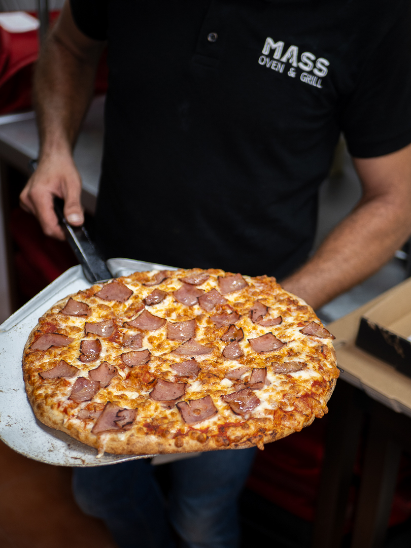 Wood-fired pizza presented by Mass Oven & Grill kitchen team